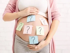 Photograph of pregnant torso cradled by hands with blue sticky notes showing question marks