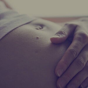 Grávida com mão na barriga Grávida com mão na barriga