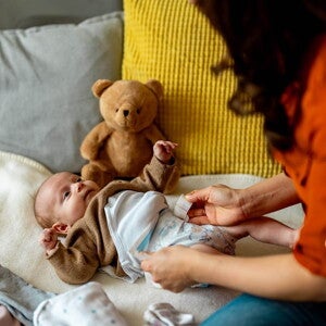 Mãe a mudar a fralda do bebé