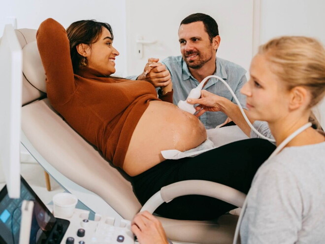Grávida a perguntar ao médico sobre o diagnóstico pré-natal Grávida a perguntar ao médico sobre o diagnóstico pré-natal