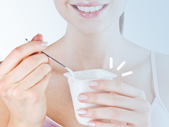Mãe a comer iogurte com vitaminas e minerais para gravidez saudável