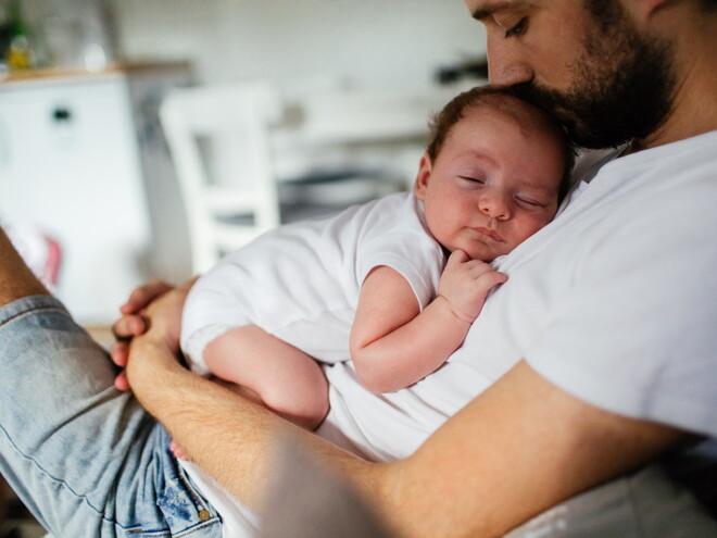 bebé a dormir ao colo do pai