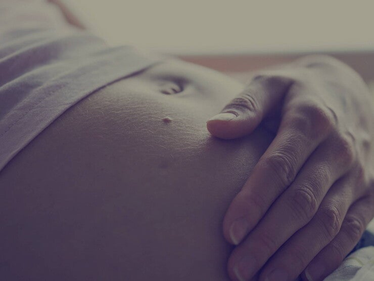 Grávida com mão na barriga Grávida com mão na barriga