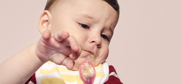 Careta do bebé a comer – a empurrar a colher Careta do bebé a comer – a empurrar a colher