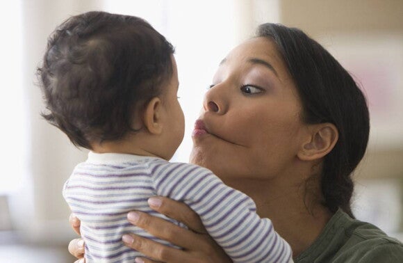 Mãe a fazer caretas para o seu bebé Mãe a fazer caretas para o seu bebé